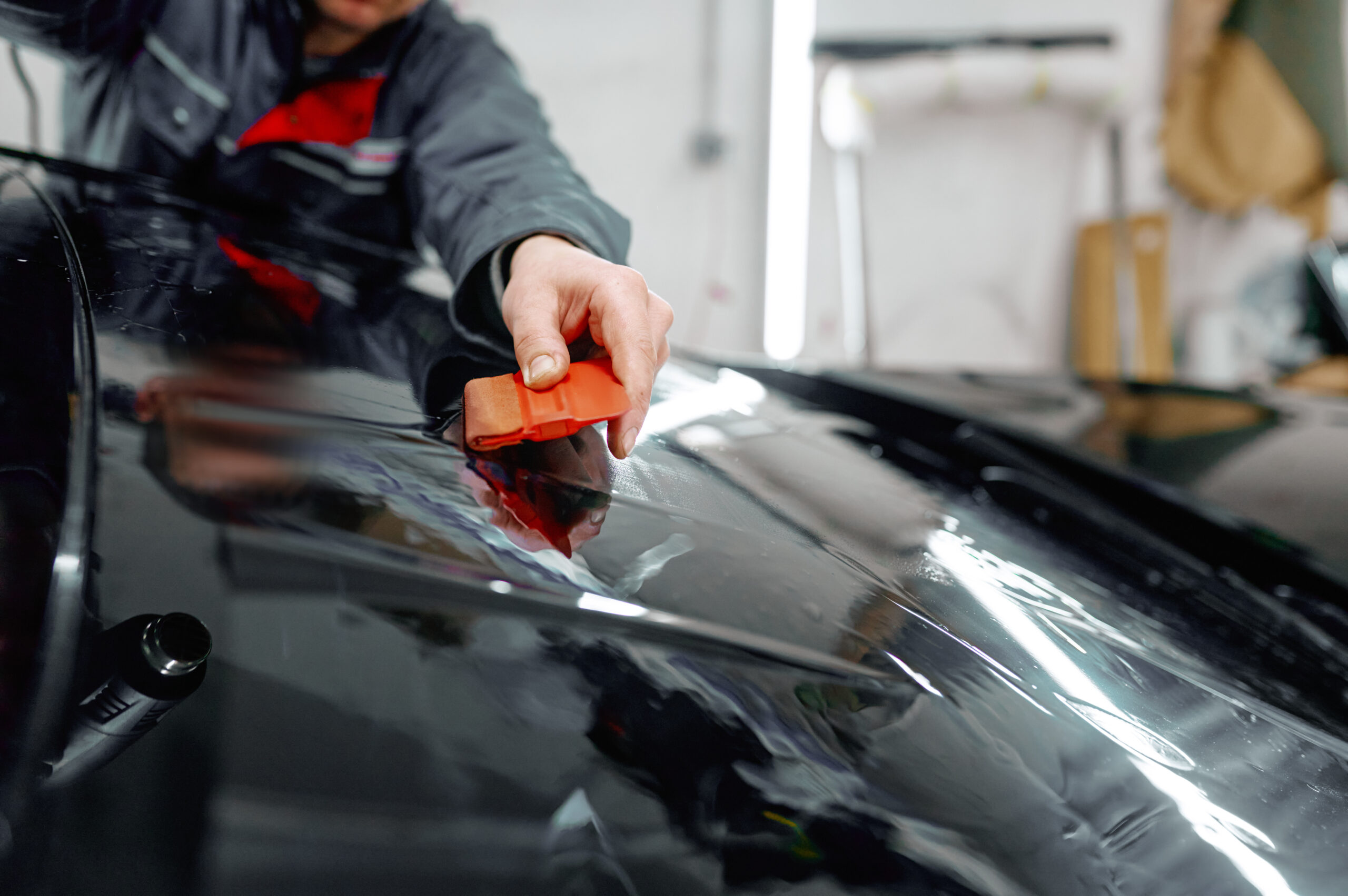 A professional applying Paint Protection Film PPF on a car.